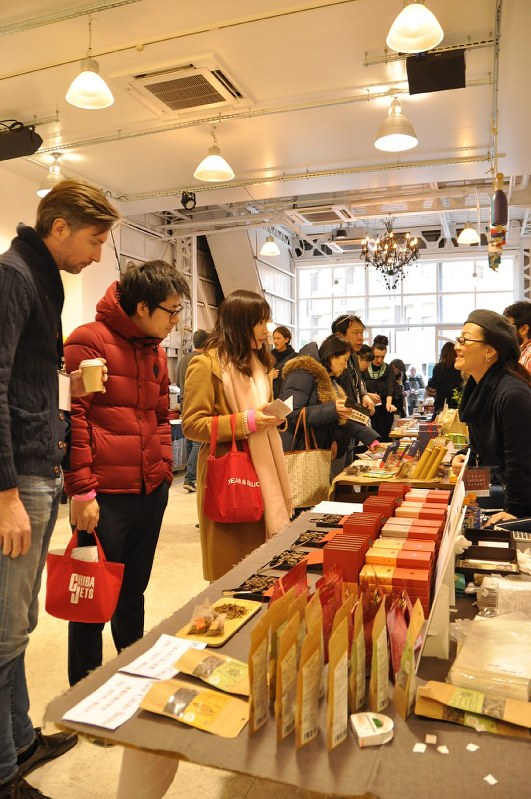 ビーン・トゥ・バー・チョコレートの実食販売イベントで、生産者の説明を受けながらチョコレートを選ぶ来場者=東京都江東区で