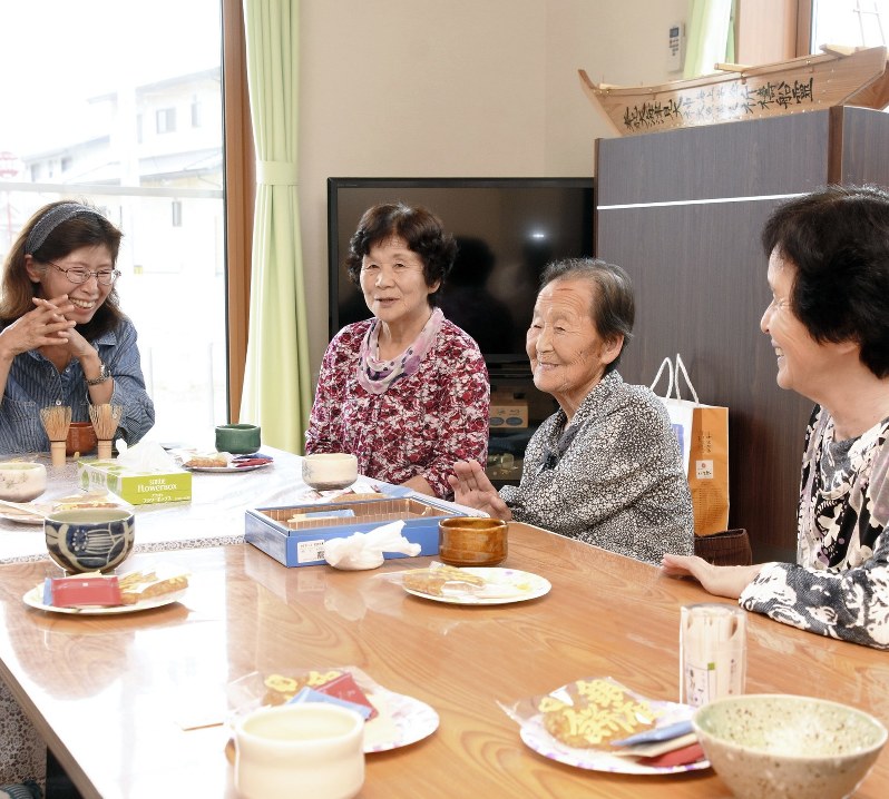 被災者たちと笑顔で会話する千代田すみ子さん(左)=宮城県気仙沼市で