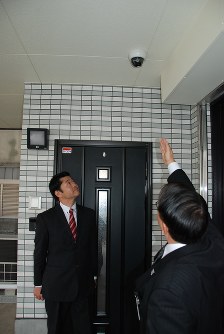 防犯カメラの設置状況について危機管理アドバイザーと確認する秋田社長＝足立区で