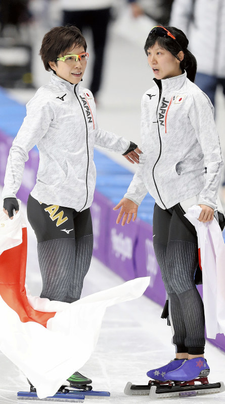 スピードスケート女子1000メートルで2位と3位になり、そろって日の丸を手にする小平奈緒(左)と高木美帆=江陵オーバルで2018年2月14日、佐々木順一撮影