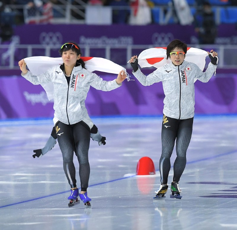 【平昌五輪】女子1000メートルを滑り終え、日の丸を手に会場の歓声に応える2位の小平奈緒(右)と3位の高木美帆=江陵オーバルで2018年2月14日午後8時15分、手塚耕一郎撮影