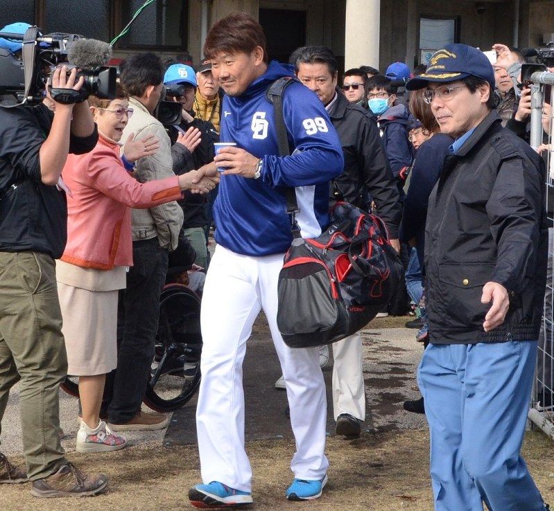群がるファンと握手する松坂(中央)。連日、報道陣のカメラが密着し、警備員の護衛がつく=沖縄県北谷町で7日