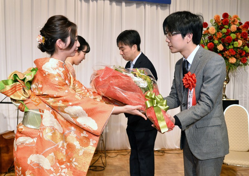 第67期王将戦第4局の前夜祭で花束を受け取る久保利明王将(右から2人目)と挑戦者の豊島将之八段(右端)=兵庫県尼崎市の都ホテルニューアルカイックで2018年2月18日、加古信志撮影