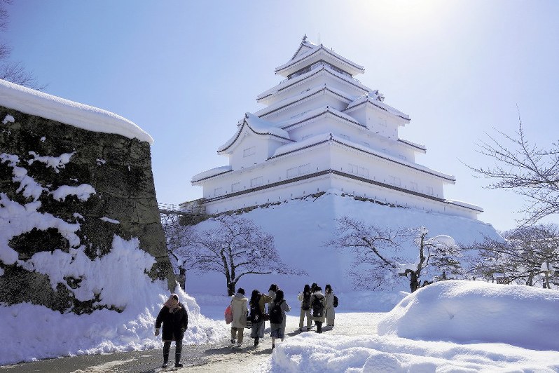150年前の1868(明治元)年、戊辰戦争の渦中に落城した鶴ケ城。雪に覆われる中、国内外からの訪問客が絶えなかった=福島県会津若松市で2018年2月14日、藤原章生撮影