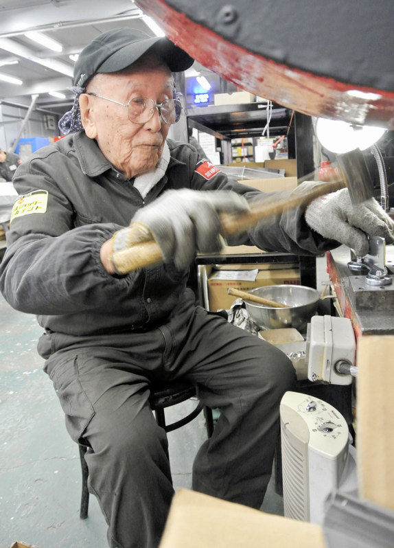 作業に励む平久守さん=東京都足立区の横引シャッターで