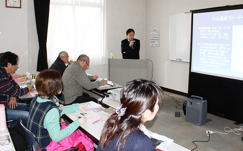 兵庫県朝来市教委文化財課の池野祐季さんの説明を聞き真剣に学ぶ受講者=同市和田山町の和田山生涯学習センターで、中治愛美撮影