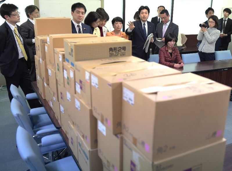 地下倉庫にあった労働時間の調査データが入った32個の段ボール箱を前に担当者に質問する野党議員ら(奥)=東京都千代田区の厚労省で2018年2月23日午後2時18分、藤井太郎撮影