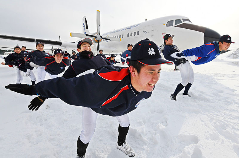 二人一組になり、飛行機の形をする補強運動に汗を流す日本航空の選手たち=石川県輪島市で2017年1月18日、山崎一輝撮影