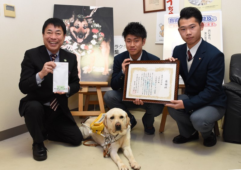 (右から)寄付金を贈った元野球部の六郷和馬さんと元サッカー部の檀上光貴さん。中部盲導犬協会の田嶋順治施設長=名古屋市港区の同協会で