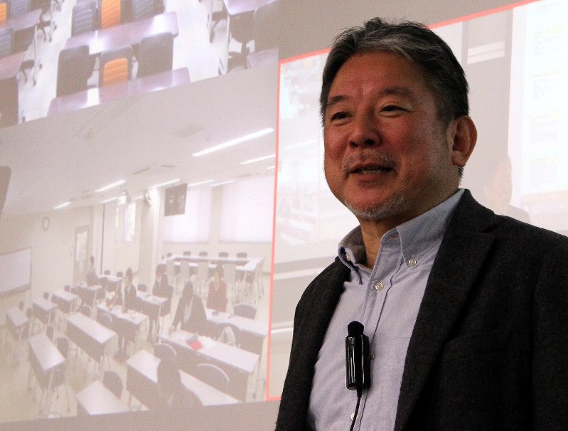 教育現場での著作権利用についての遠隔授業で、スクリーンの向こうの学生に向かって語りかける久保田裕さん=大阪府柏原市で