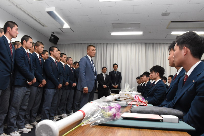 卒業する3年生ら(右側の列)に声をかける森田泰弘監督(中央)と見守る現役部員ら=名古屋市名東区の東邦高で