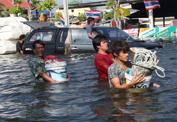 腰の高さまで冠水した道路を歩く人たち=バンコク郊外バンブアトンで2011年11月1日、山本晋撮影