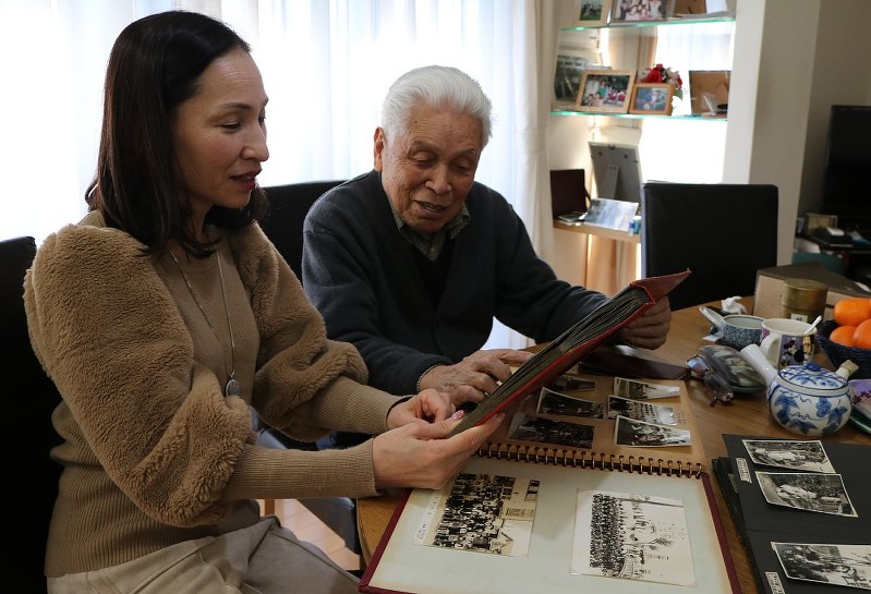 整理するアルバムを見ながら、思い出を語る中山和夫さん(右)と次女の小澤明美さん=東京都葛飾区で
