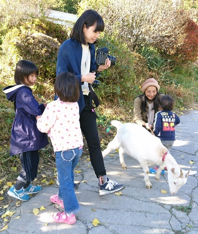 宇津孝子さん(右奥)と子どもたちを撮影する江連麻紀さん(中央)=長野県伊那市で2017年10月30日、鈴木敦子撮影
