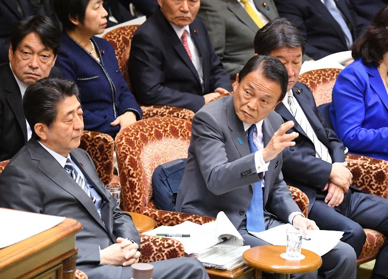 参院予算委員会で学校法人「森友学園」への国有地売却問題に関する一部報道についての答弁のため挙手する麻生太郎財務相(前列左から2人目)。左端は安倍晋三首相=国会内で2018年3月2日、川田雅浩撮影