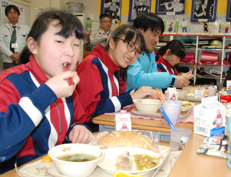 サケの豆乳ソースがけやワカメのスープなど、地産地消にこだわった給食を水産加工業者らと味わう釜石小6年の児童