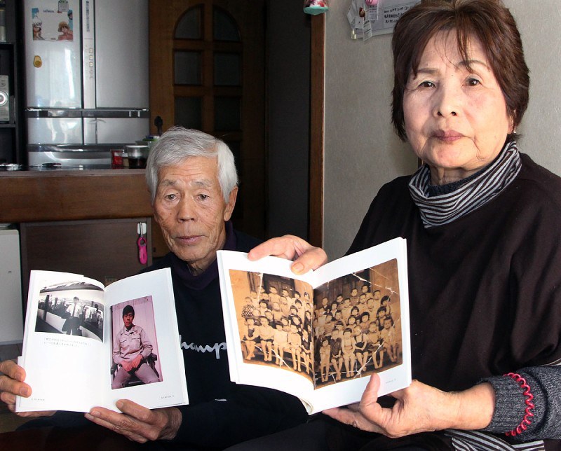 プレゼントされた人生Bookを広げる赤星千代子さん(右)と良之助さん=北九州市戸畑区で、比嘉洋撮影