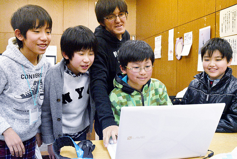 曽我悠真さん(右から3人目)とプログラミングを学ぶ児童ら=岡山市南区で、林田奈々撮影