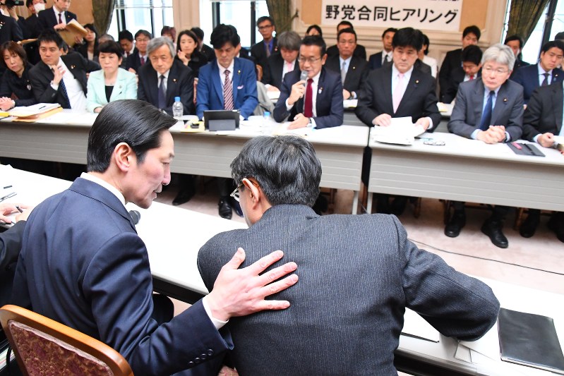 学校法人「森友学園」への国有地売却に関する財務省の決裁文書改ざんについての野党合同の会合に出席し担当者と話す同省の富山一成理財局次長(手前左)=国会内で2018年3月12日、川田雅浩撮影