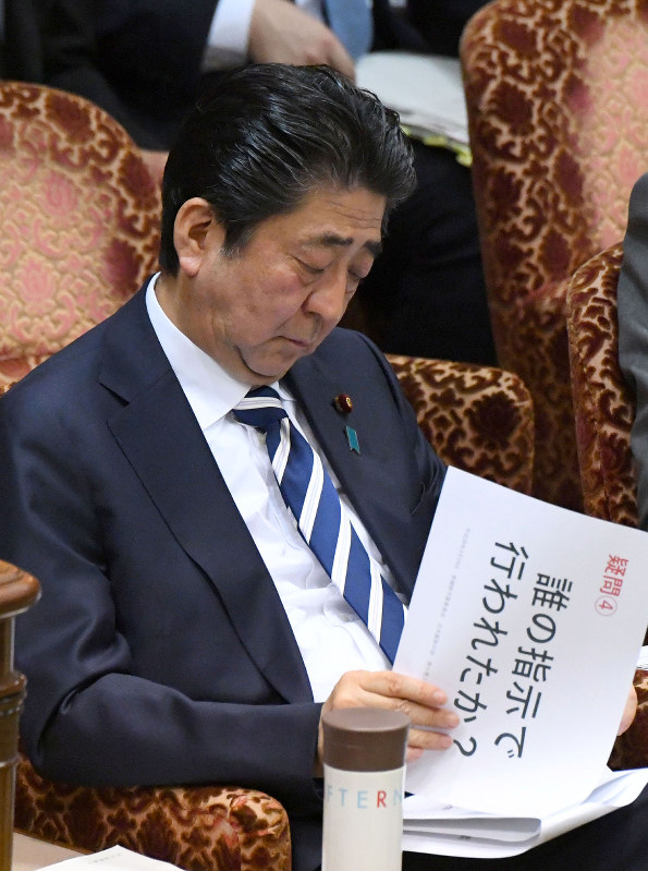 参院予算委員会で「誰の指示で行われたか?」と書かれた質問資料を見る安倍晋三首相=国会内で19日、川田雅浩撮影