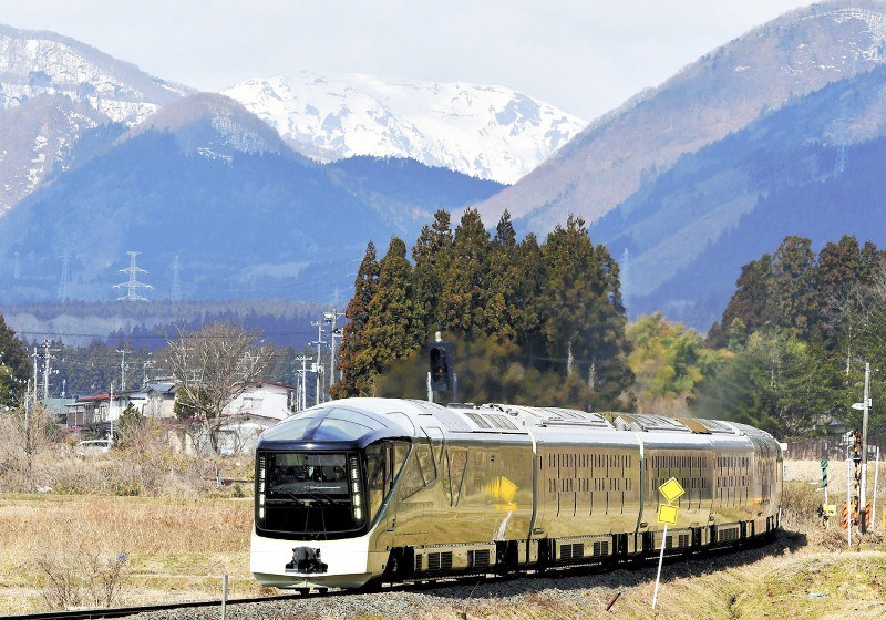 鳴子の雪山を背に走る「四季島」=宮城県大崎市のJR陸羽東線川渡温泉-池月駅間で2018年3月19日、山田研撮影