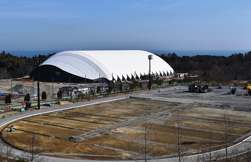 一部再開に向け復旧工事が進むJヴィレッジ。後方は新設の全天候型練習場=楢葉町山田岡で