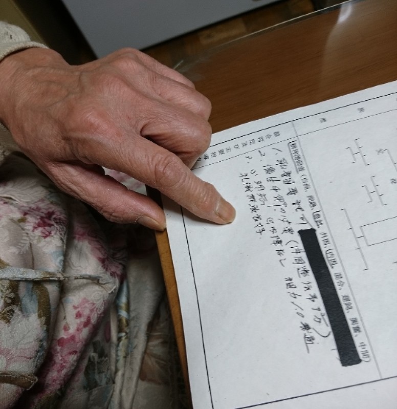 県の相談機関の判定記録票を手にする飯塚さん