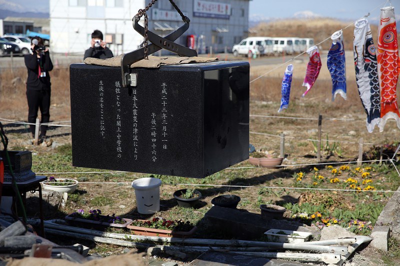 移設のためつり上げられる慰霊碑=宮城県名取市で2018年3月24日午前9時9分、喜屋武真之介撮影