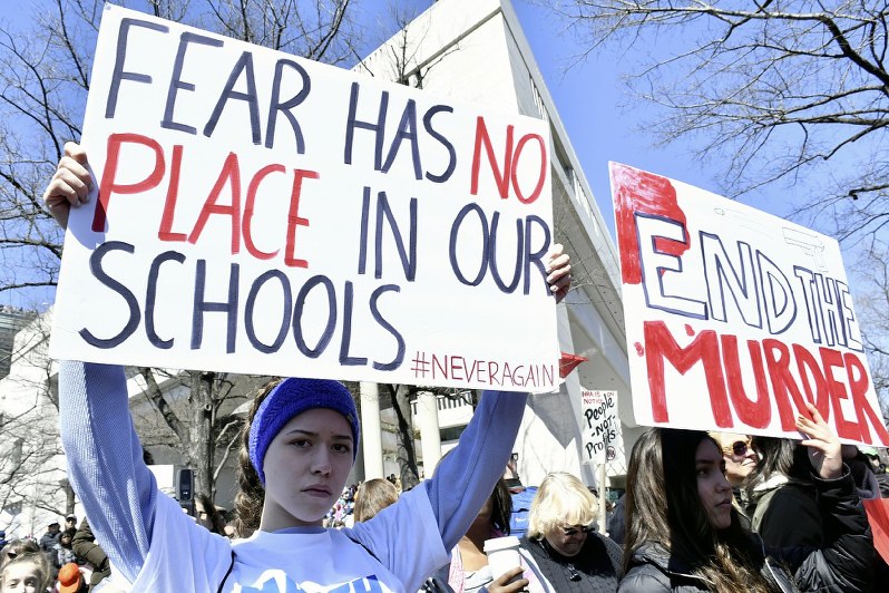 「学校に恐怖が占める場所はない」などの主張を掲げ、銃規制を訴える「私たちの命のための行進」参加者=米ワシントンで2018年3月24日、國枝すみれ撮影