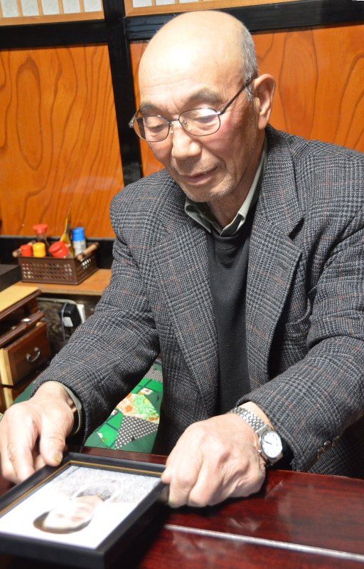 妻澄子さんの遺影を手に水害当時を振り返る長谷川義晴さん=金山町越川で