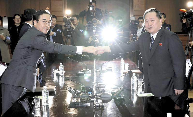 板門店の北朝鮮側施設「統一閣」で閣僚会談を前に握手する韓国の趙明均統一相(左)と北朝鮮の祖国平和統一委員会の李善権委員長=2018年3月29日、ロイター