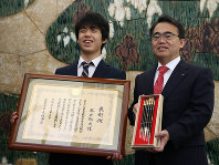 愛知県の特別表彰を受けた藤井聡太六段（左）。右は記念品の豊橋筆を持つ大村秀章知事＝名古屋市中区の愛知県公館で２０１８年３月３０日午前１１時４６分、兵藤公治撮影