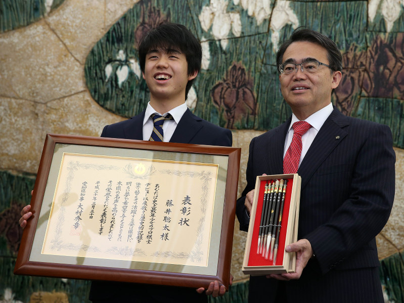 愛知県の特別表彰を受けた藤井聡太六段(左)。右は記念品の豊橋筆を持つ大村秀章知事=名古屋市中区の愛知県公館で2018年3月30日午前11時46分、兵藤公治撮影