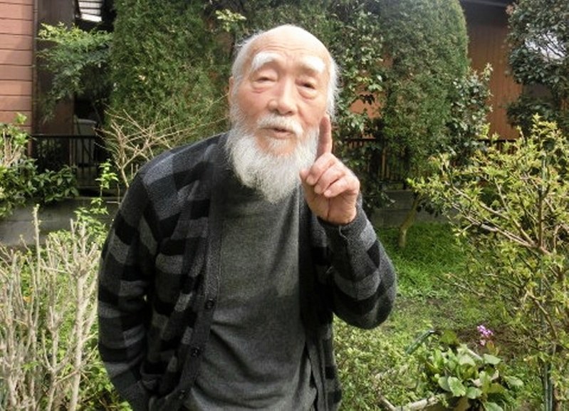 「わが民族はひとつ。統一の春は来るよ」と自宅の庭で語る鄭敬謨さん=横浜市で、鈴木琢磨撮影
