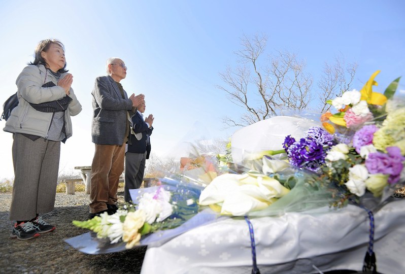高校生ら8人が死亡した雪崩事故から1年がたち、現地の献花台で手を合わせる人たち=栃木県那須町で3月27日、宮間俊樹撮影