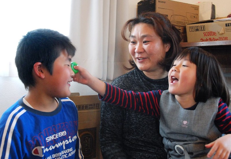 子どもたちに囲まれて笑顔を見せる村上さんだが、将来への不安は尽きない=熊本県益城町で2018年3月24日、中里顕撮影