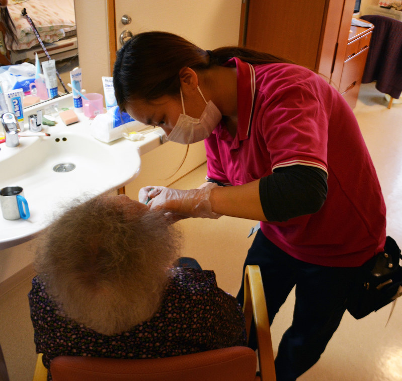 専門家の指導を受けながら入所者の口腔ケアをする「マナハウス」の職員=福岡市西区で、有田浩子撮影
