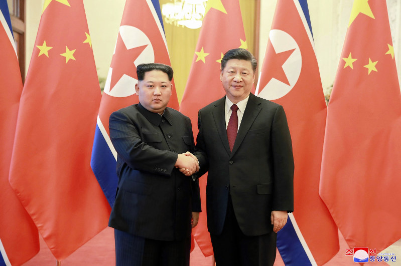 習近平国家主席(右)と握手して記念撮影する金正恩朝鮮労働党委員長=北京の人民大会堂で2018年3月26日、朝鮮中央通信・朝鮮通信