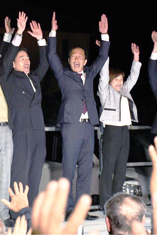 徳島・東みよし町長選に当選し、支援者らと万歳三唱で喜びを分かち合う松浦敬治氏(中央)=同町加茂の事務所前で、大坂和也撮影
