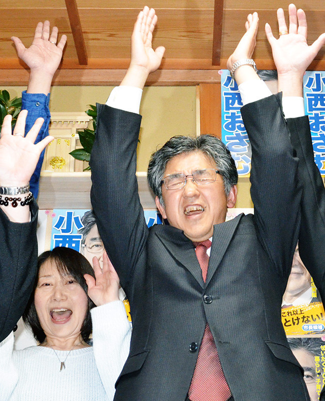 滋賀・近江八幡市長選で当選確実となり万歳する小西理氏(右)ら=同市武佐の事務所で=2018年4月15日、礒野健一撮影