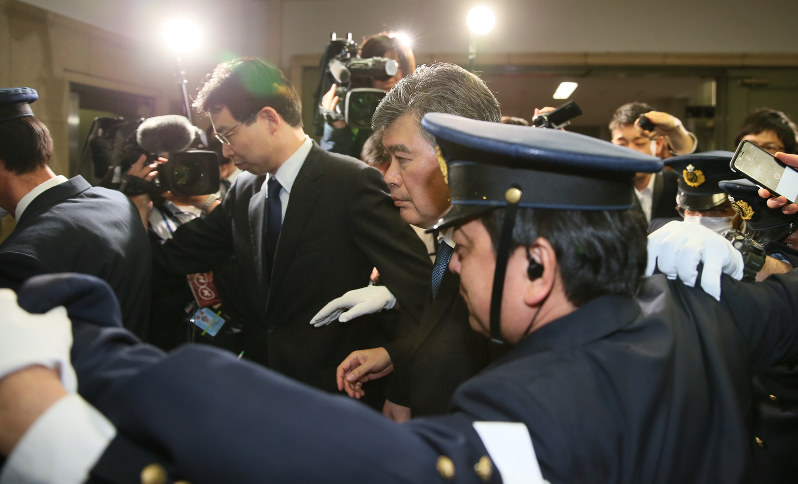 警備員らに囲まれ、財務省を後にする福田淳一事務次官(中央)=東京都千代田区で2018年4月16日午後6時21分、佐々木順一撮影