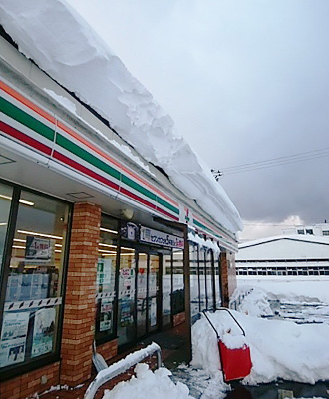 屋根からせり出すほど雪が降り積もった店舗=福井県内で2月6日、コンビニ加盟店ユニオン提供