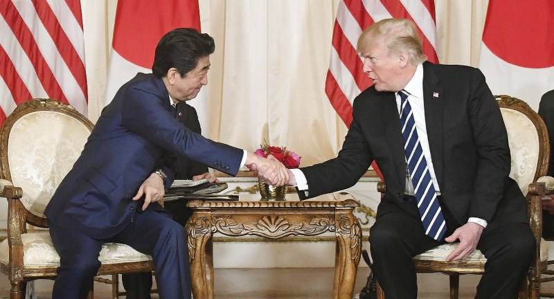トランプ米大統領と握手する安倍首相=米フロリダ州パームビーチで17日、共同