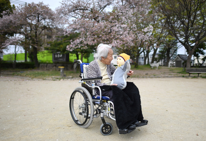 膝に乗せた「テレノイド」に語りかける内田文子さん=兵庫県尼崎市で2018年4月5日、久保玲撮影