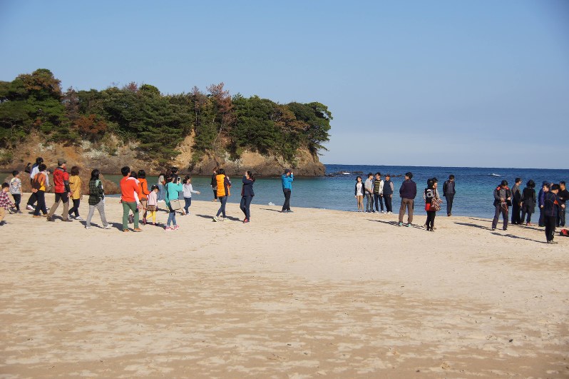 「日本の渚百選」になった対馬北部の三宇田浜を見物する韓国人観光客=対馬観光物産協会提供