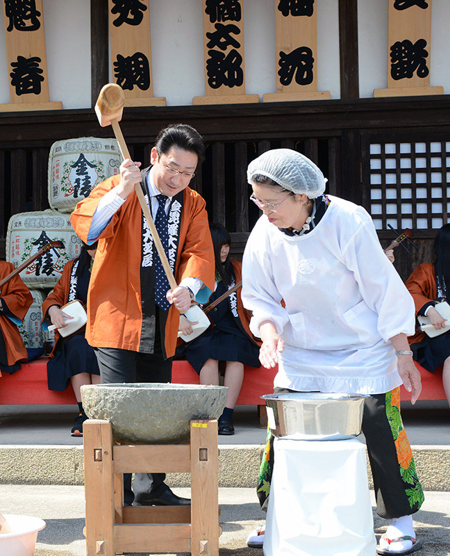 来場者に感謝の気持ちを込めて餅をつく芝翫さん(左)=香川県琴平町の金丸座前で、山中尚登撮影