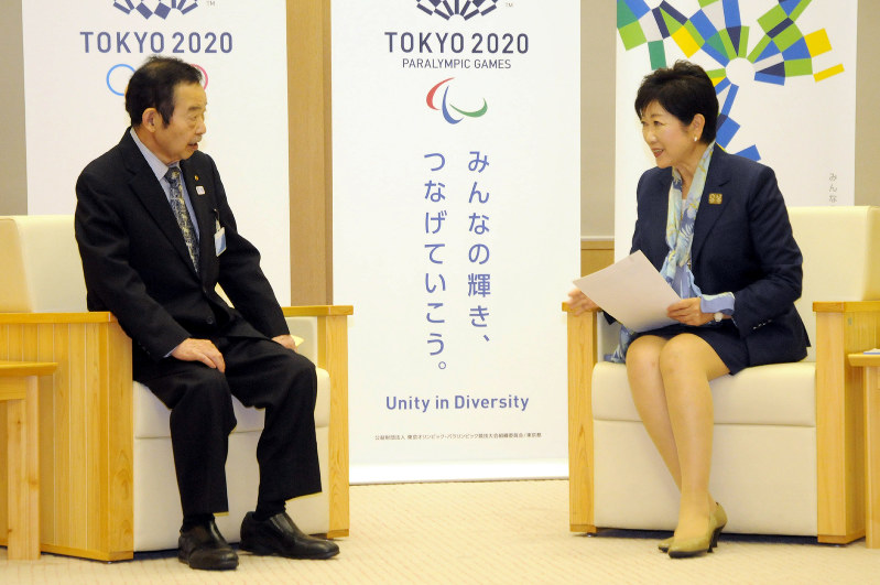 東京都の受動喫煙防止条例案の見直しを求める要望書などを小池百合子知事(右)に渡した原田啓助・東京都生活衛生同業組合連合会副会長=東京都新宿区の東京都庁で2018年4月24日、芳賀竜也撮影