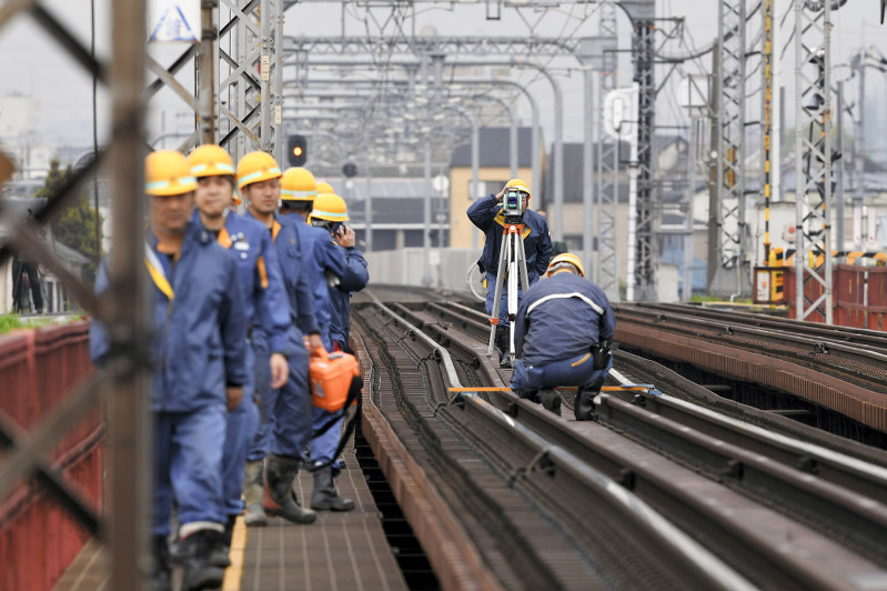 近鉄南大阪線「大和川橋梁」上の線路を点検する作業員=2018年4月25日午前11時12分、猪飼健史撮影