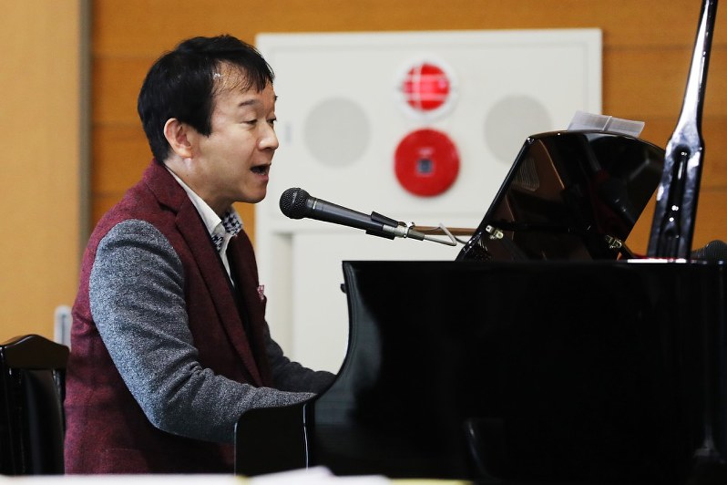作詞、作曲した飯舘村立認定こども園の園歌をピアノで弾き語りする臼井真さん=福島県飯舘村で1日、喜屋武真之介撮影