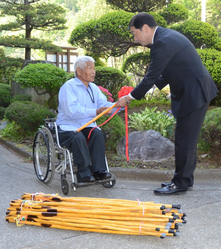 本多一助さん(左)から3000本目のつえを受け取る上野村の黒沢八郎村長=群馬県上野村で2018年4月28日午後3時35分、鈴木敦子撮影
